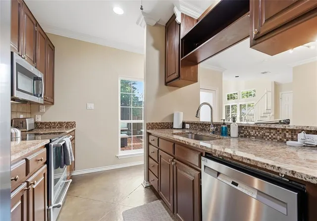 a kitchen with stainless steel appliances granite countertop a sink stove and cabinets