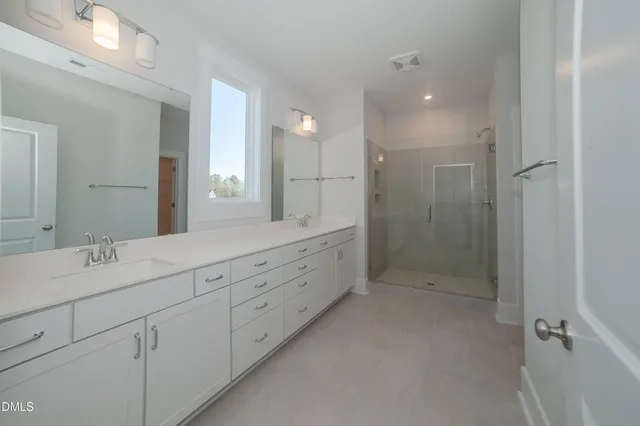 a spacious bathroom with double sink and a mirror