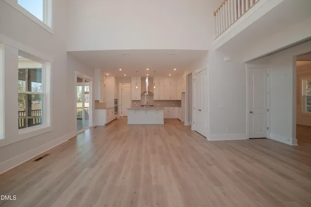 a view of a big room with wooden floor and windows