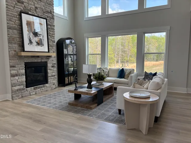 a living room with furniture a fireplace and a large window