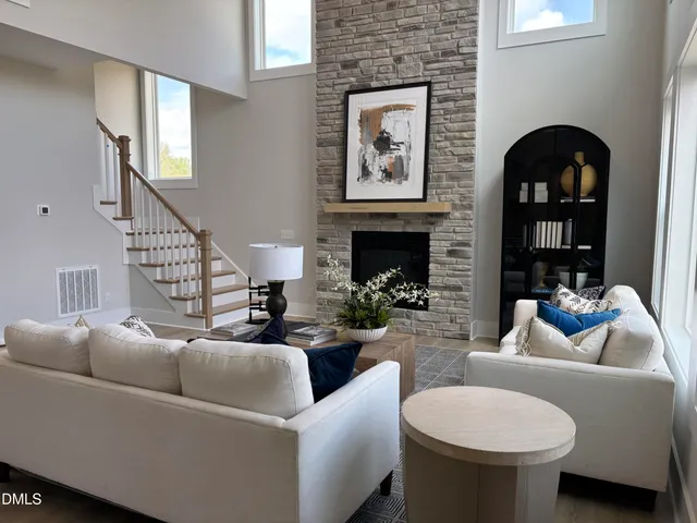 a living room with furniture a fireplace and a potted plant