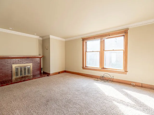 an empty room with a fireplace and windows