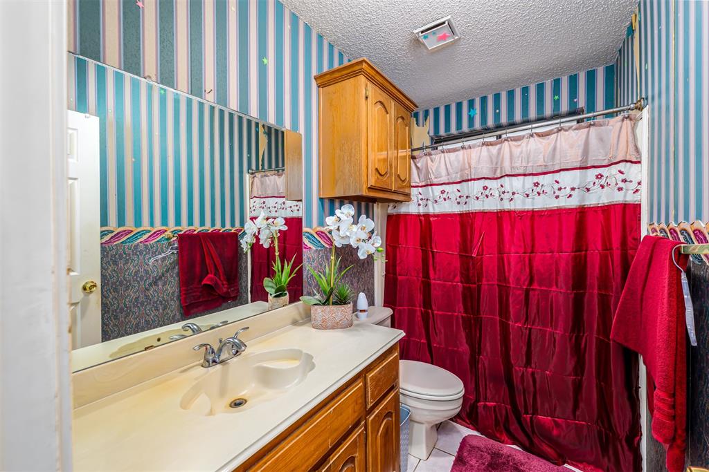 601 Houston School Road Red Oak, TX 75154 - Photo 12 of 32 Bathroom featuring wallpapered walls, toilet, vanity, tile patterned floors, and a shower with curtain