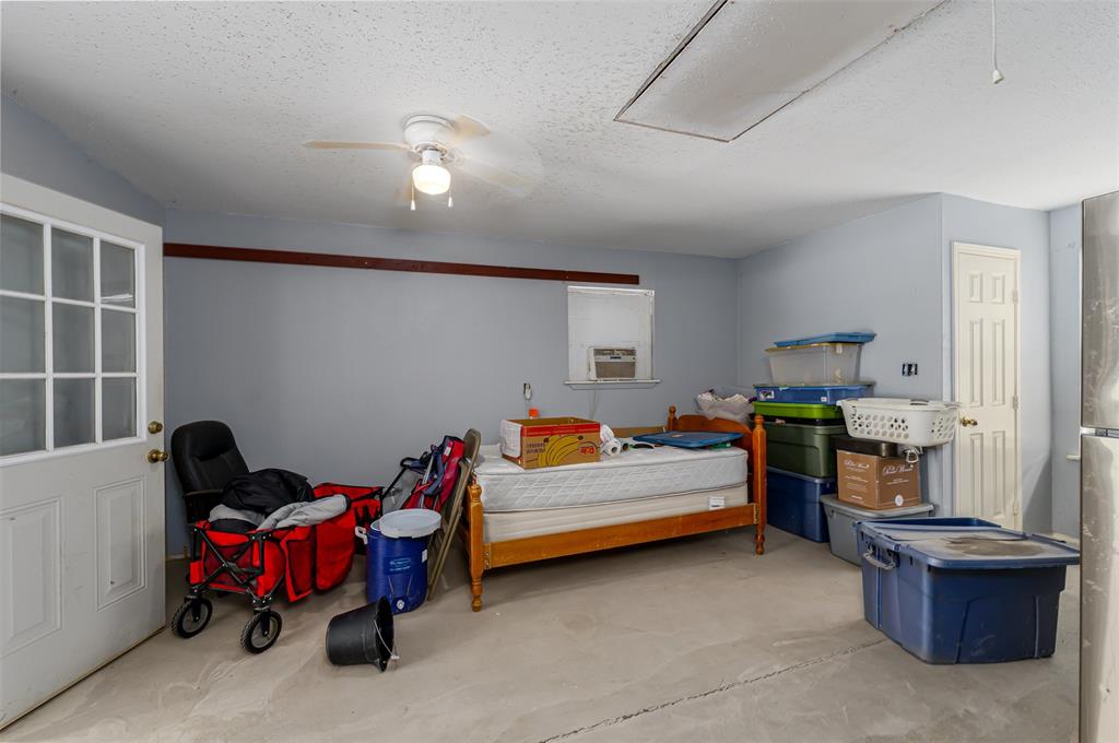 601 Houston School Road Red Oak, TX 75154 - Photo 24 of 32 Bedroom featuring a textured ceiling, concrete flooring, and a ceiling fan