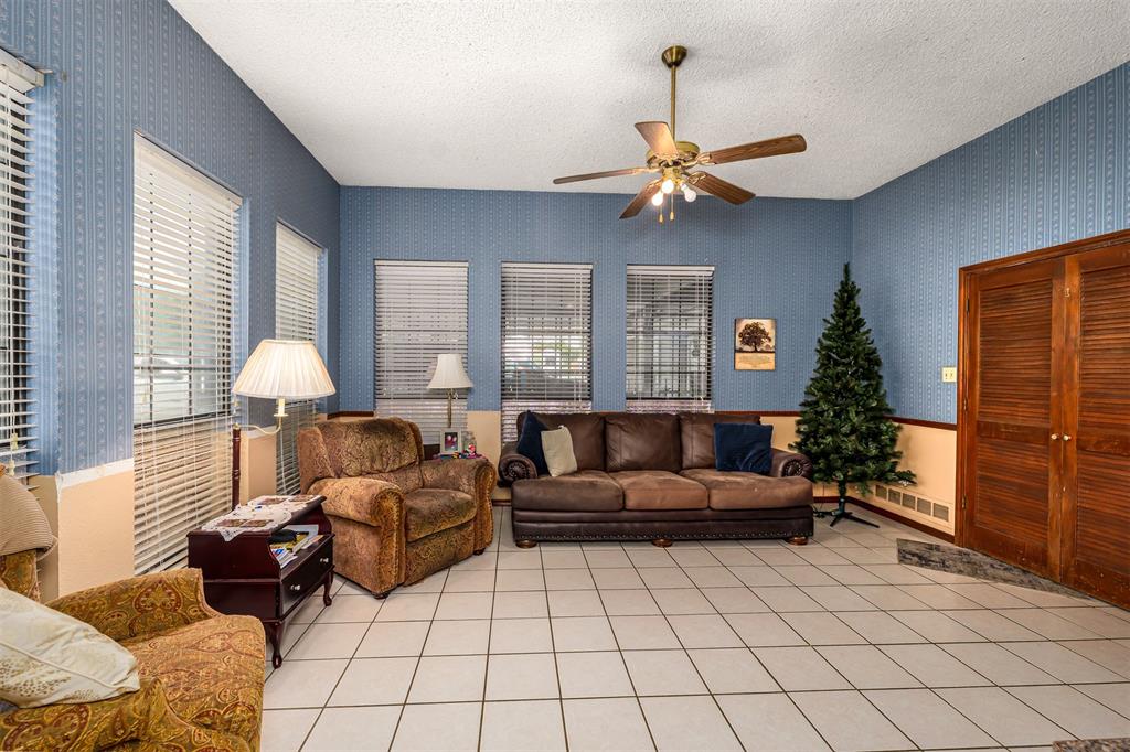 601 Houston School Road Red Oak, TX 75154 - Photo 6 of 32 Living area with wallpapered walls, a ceiling fan, a textured ceiling, and light tile patterned floors