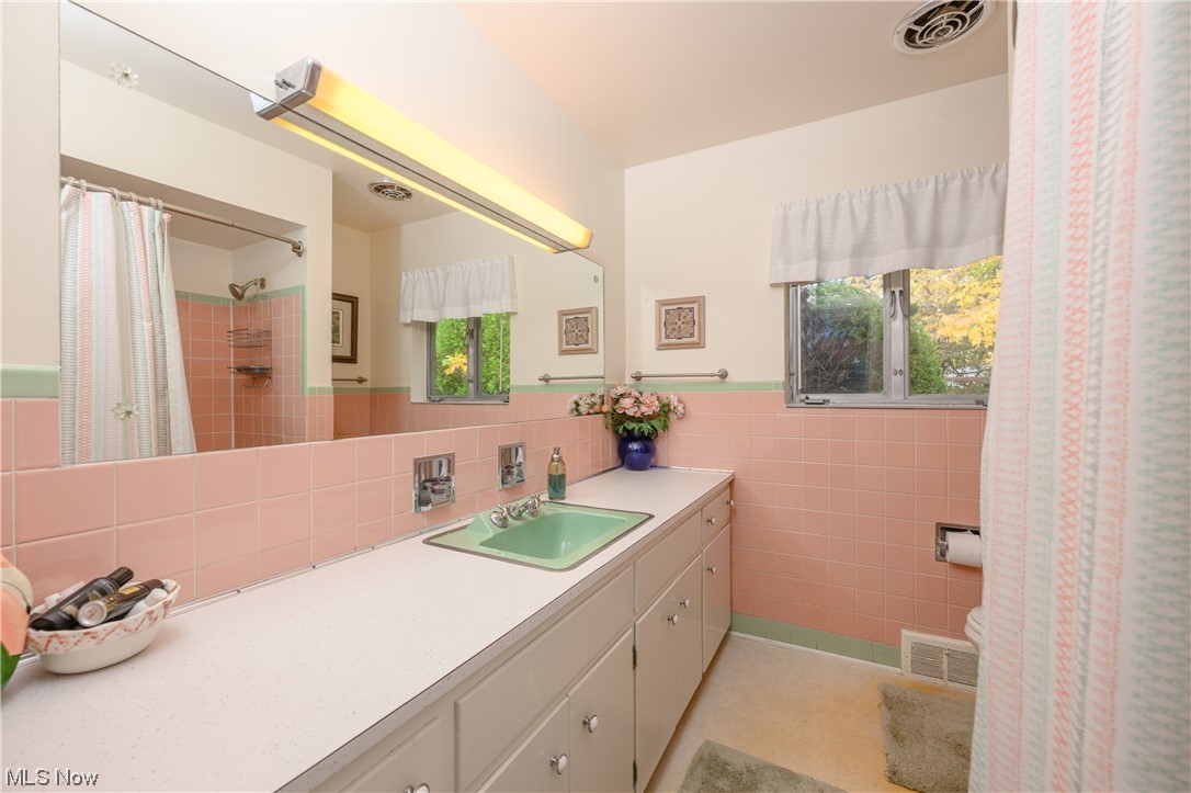 2969 Chamberlain Road Akron, OH 44333 - Photo 18 of 33 Bathroom featuring vanity, toilet, tile walls, and tasteful backsplash