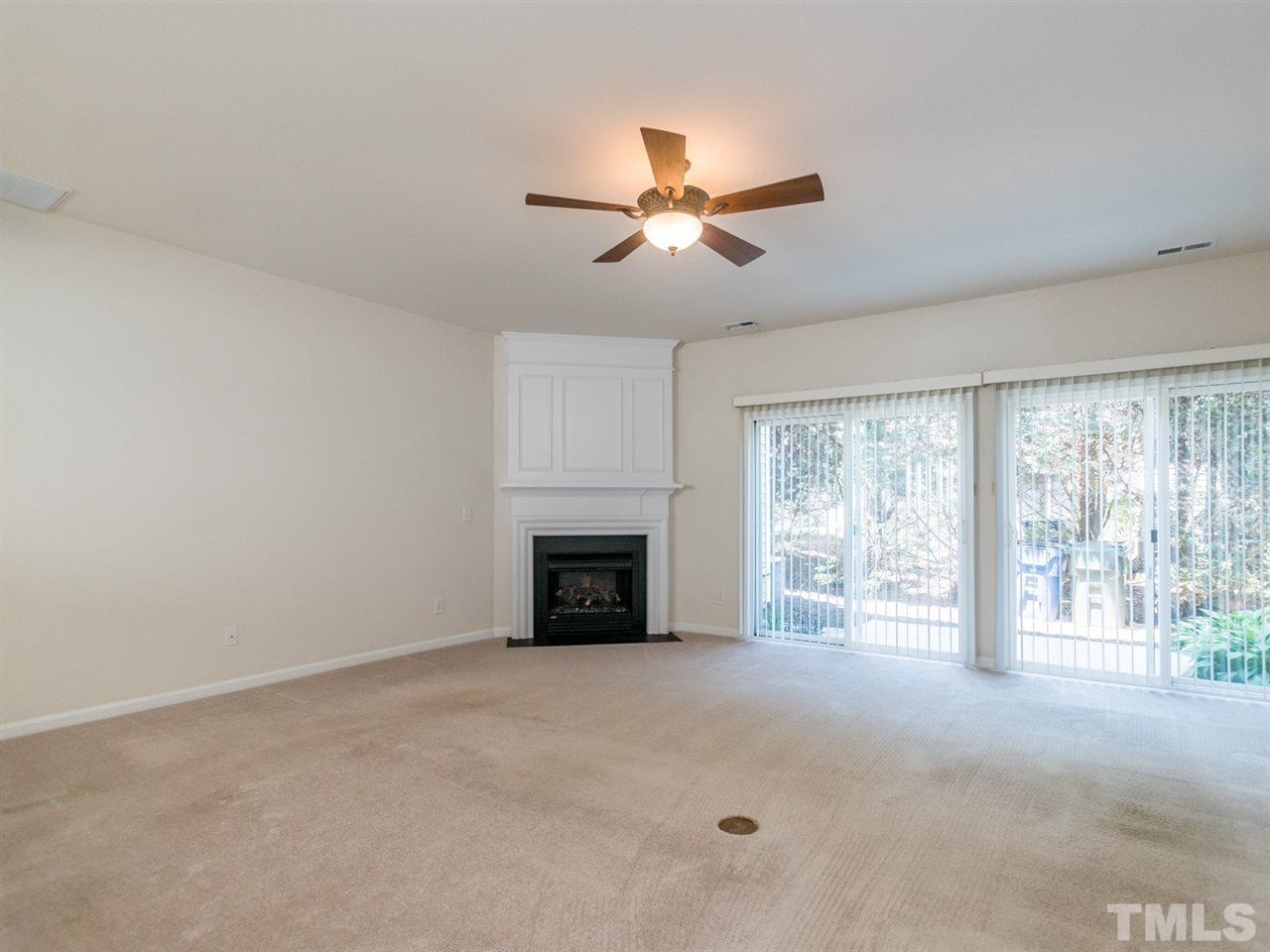 8518 Mt Valley Lane Raleigh, NC 27613 - Photo 8 of 20 a view of an empty room with a fireplace and a window