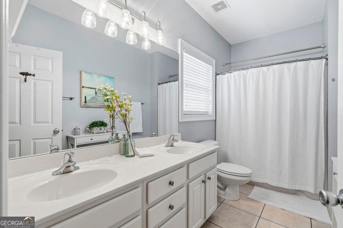 172 Mays Road Milledgeville, GA 31061 - Photo 26 of 54 a bathroom with double vanity sink a toilet and a mirror