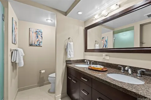 a bathroom with a granite countertop sink mirror and toilet