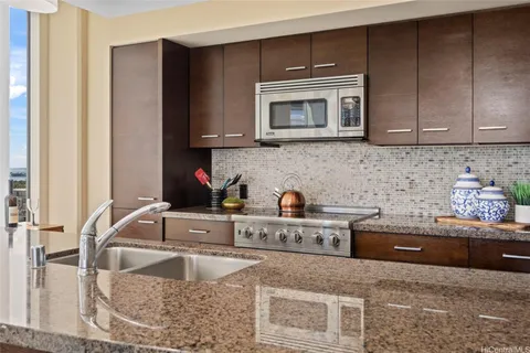 a kitchen with granite countertop a sink and a stove top oven