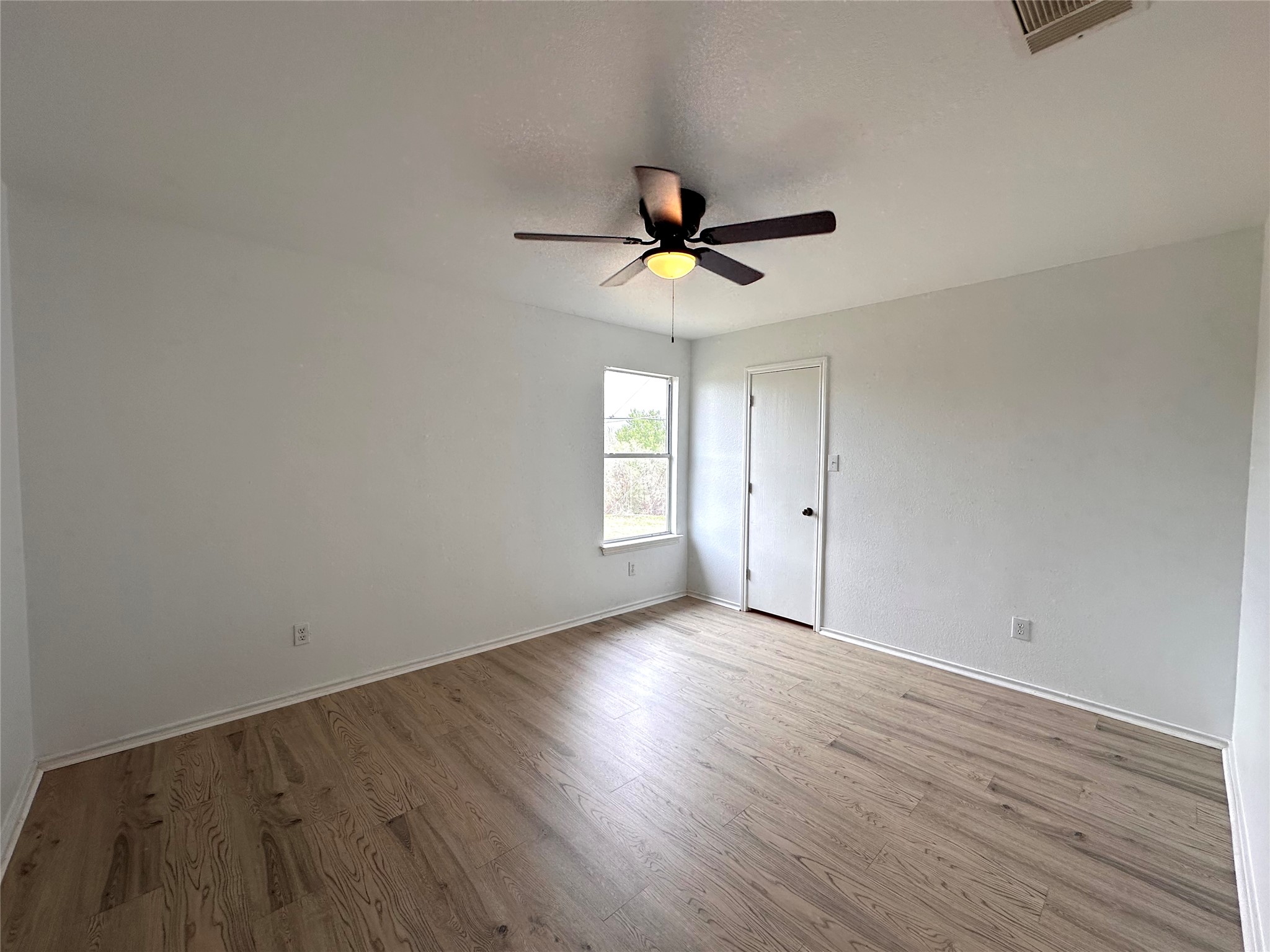 722 Lavaca Loop Elgin, TX 78621 - Photo 14 of 24 Empty room featuring wood finished floors and a ceiling fan