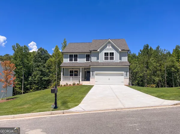 a front view of a house with a garden and yard