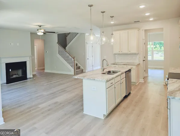 a kitchen that has a lot of cabinets in it and wooden floor