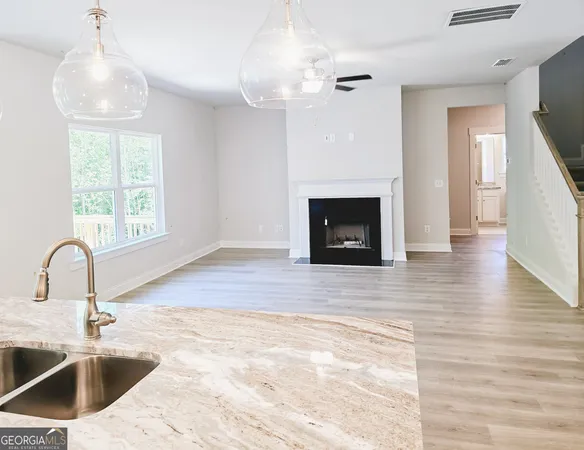 a kitchen with granite countertop a stove a sink and a wooden floor