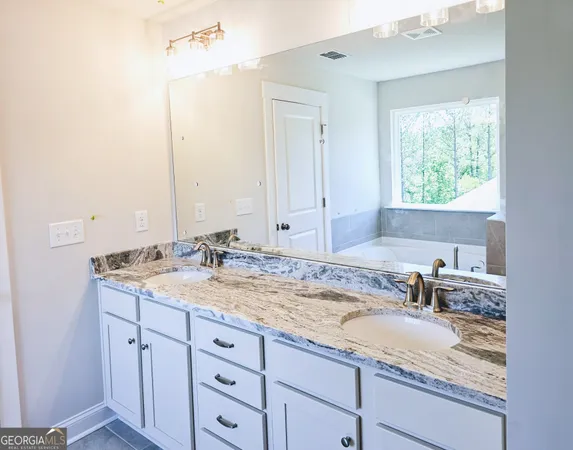 a bathroom with a granite countertop sink and a mirror