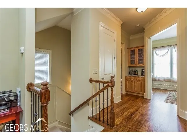 a view of a hallway with wooden floor and furniture
