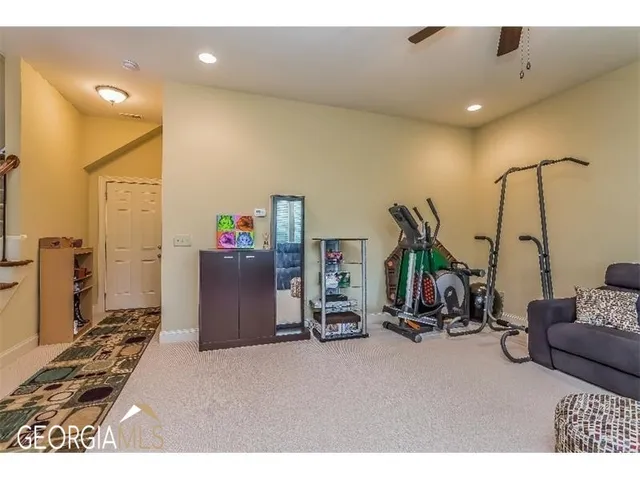 a living room with a hard wood floor and gym equipment