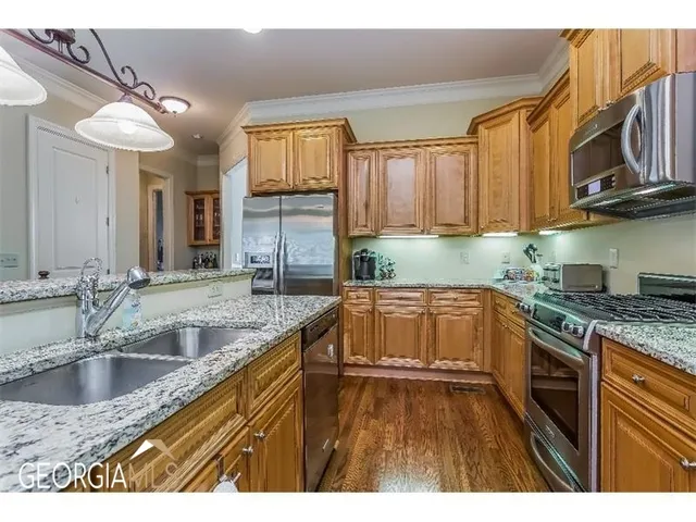 a kitchen with stainless steel appliances granite countertop a sink stove and cabinets