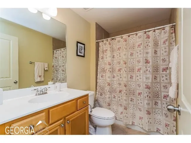 a bathroom with a sink a toilet and shower curtain