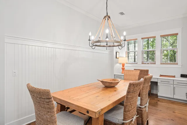 a view of a dining room with furniture a chandelier and wooden floor