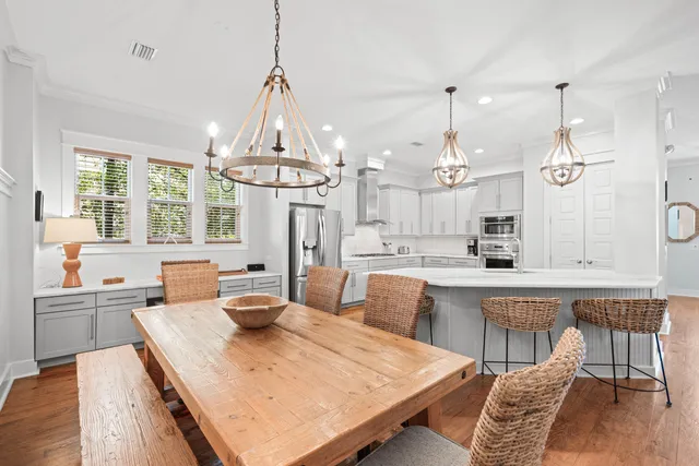 a view of a dining room with furniture a chandelier and wooden floor