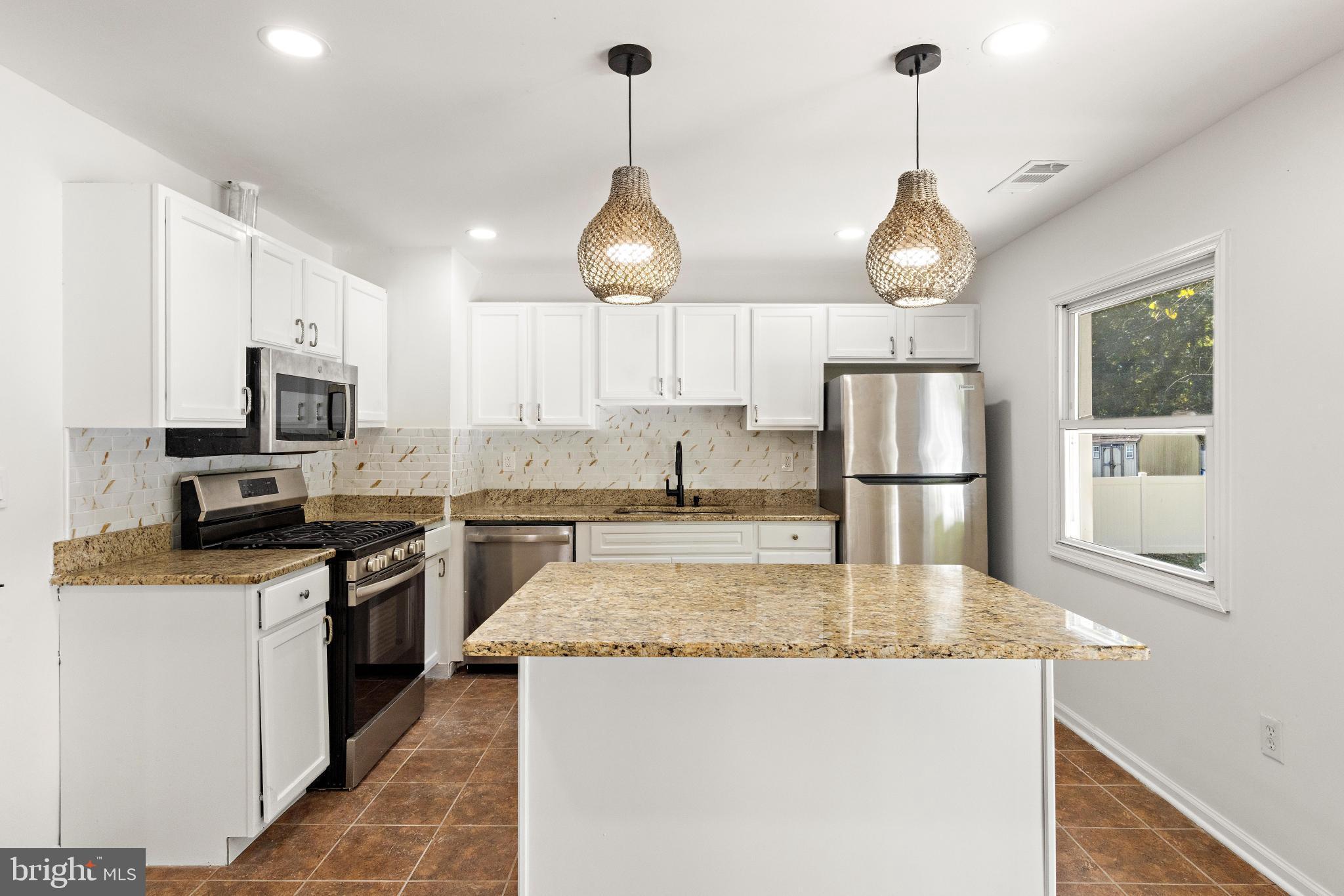 716 6th Road Newtonville, NJ 08346 - Photo 9 of 40 a kitchen with stainless steel appliances granite countertop a sink a stove a refrigerator and cabinets