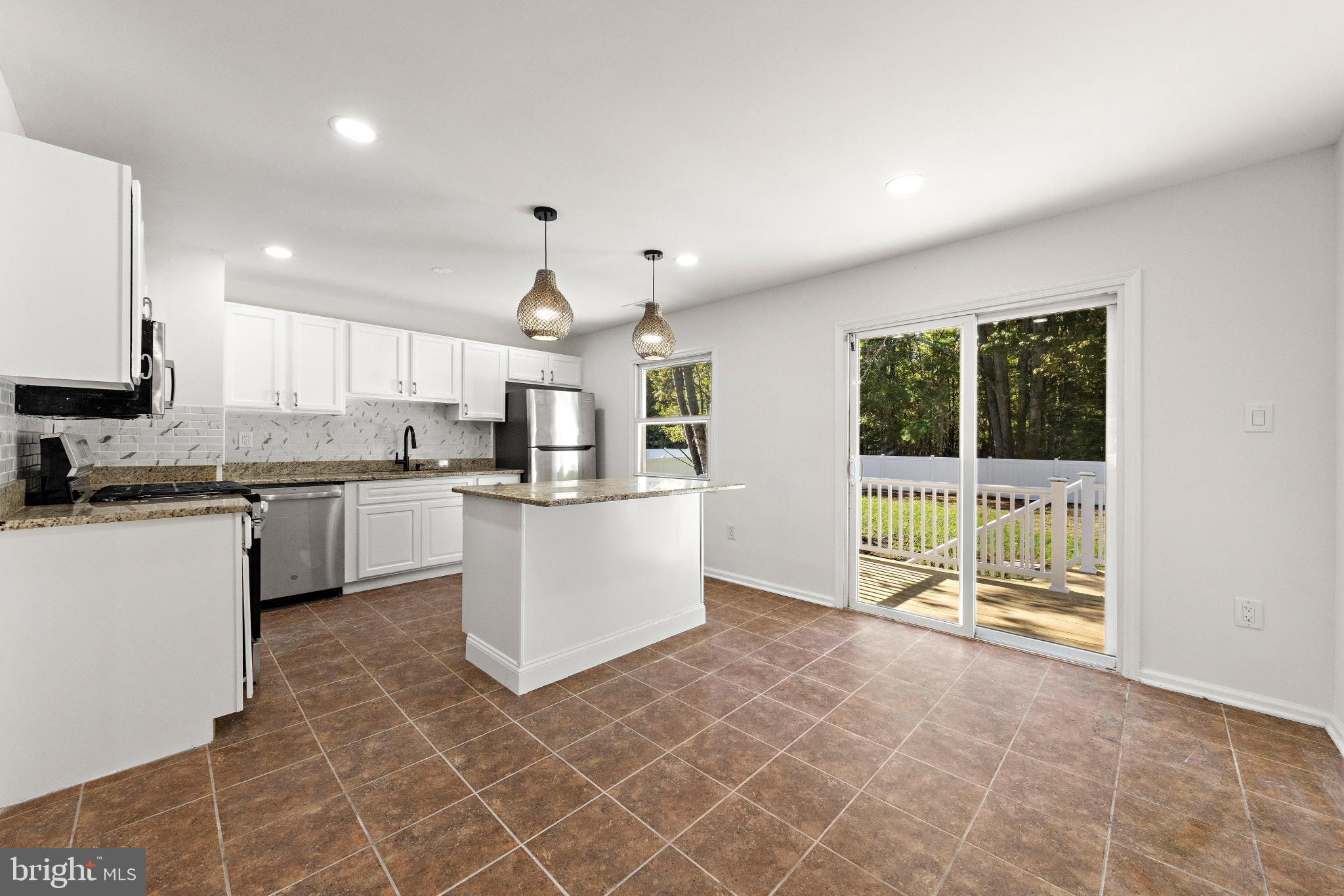 716 6th Road Newtonville, NJ 08346 - Photo 10 of 40 a kitchen with a sink a counter top space cabinets and stainless steel appliances