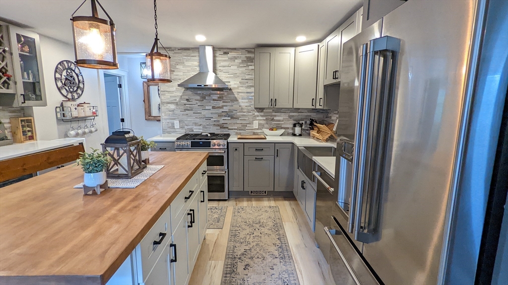 a kitchen with stainless steel appliances granite countertop sink stove and refrigerator
