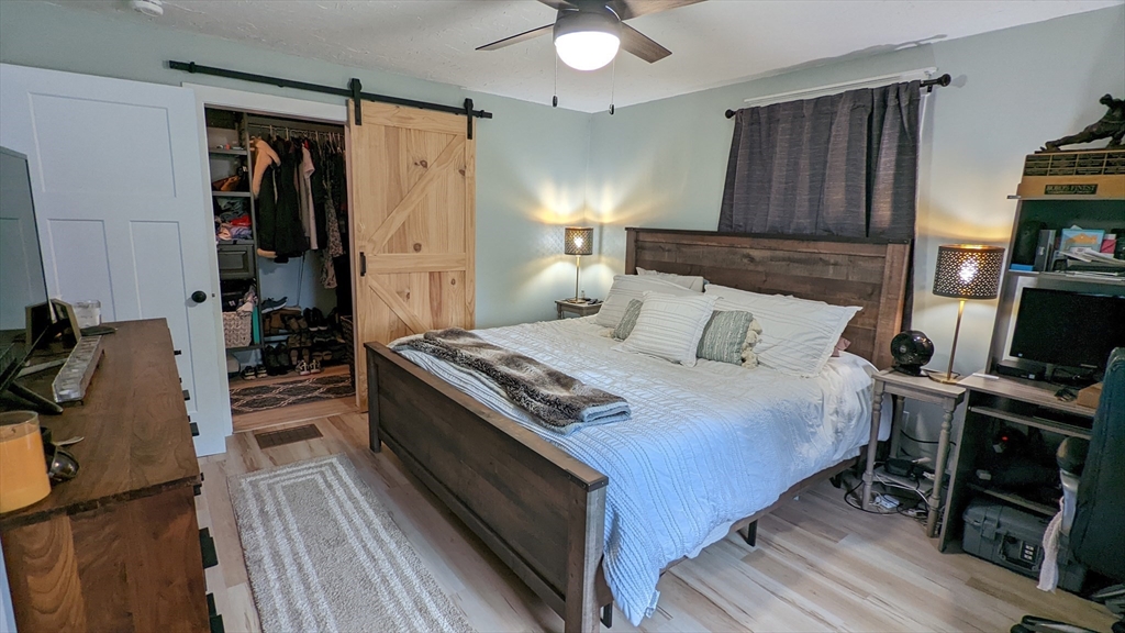 76 Milk Street, Unit 1 Westborough, MA 01581 - Photo 13 of 19 a bedroom with a bed and a flat tv screen on a dresser