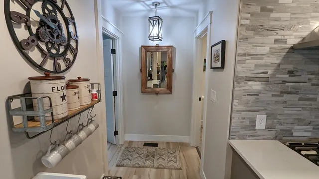 a view of a hallway with entryway wooden floor and front door