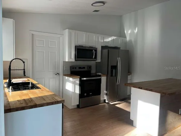 a kitchen with a refrigerator and a stove top oven