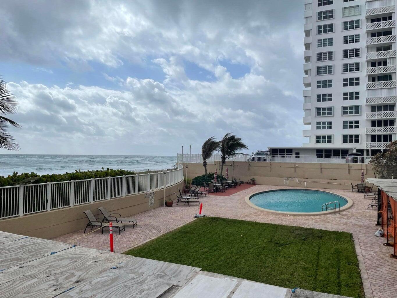 1180 South Ocean Boulevard, Unit 5C Boca Raton, FL 33432 - Photo 2 of 43 a view of a swimming pool with a patio and a yard