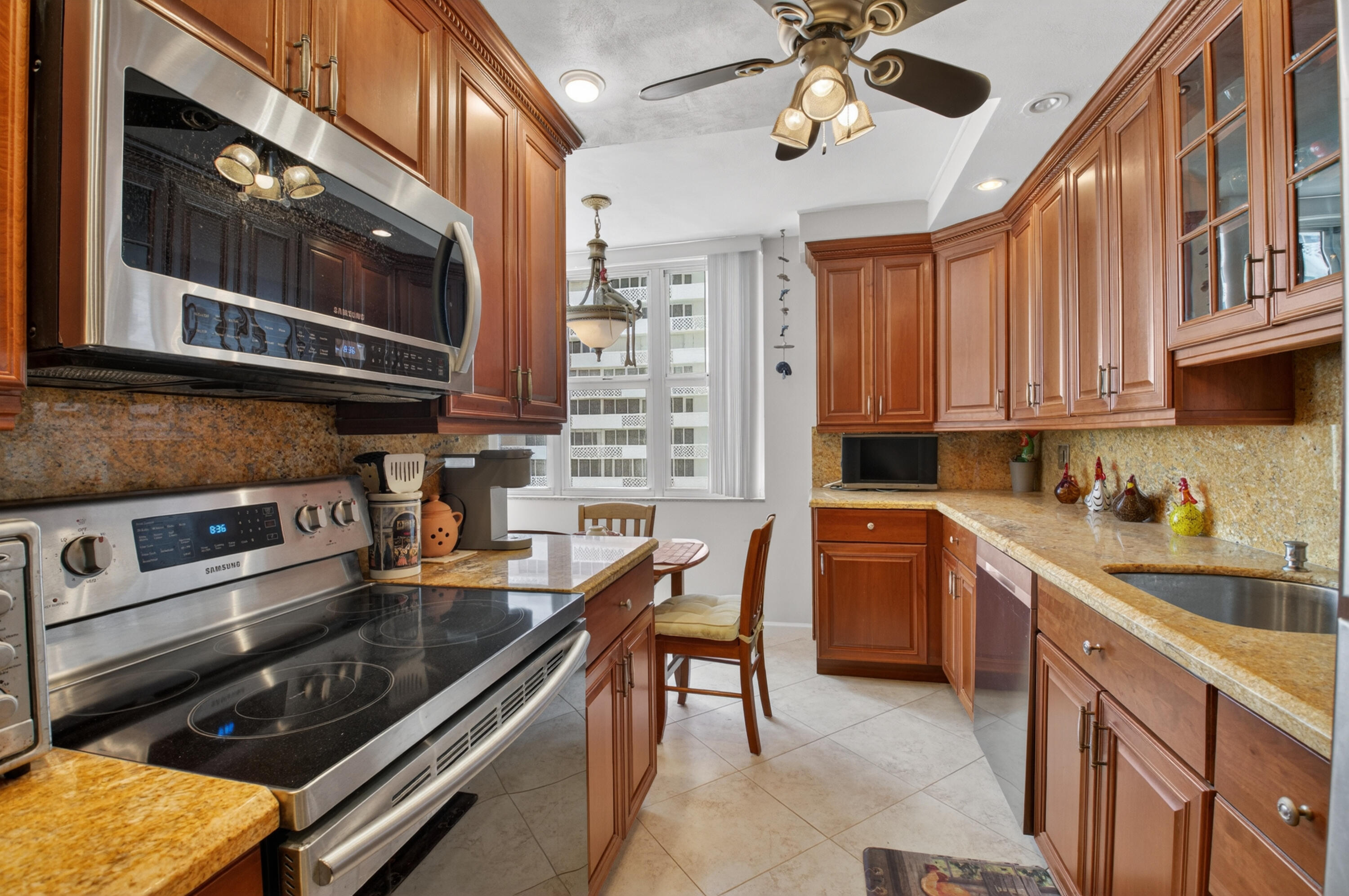 1180 South Ocean Boulevard, Unit 5C Boca Raton, FL 33432 - Photo 24 of 43 a kitchen with stainless steel appliances granite countertop a stove and a microwave