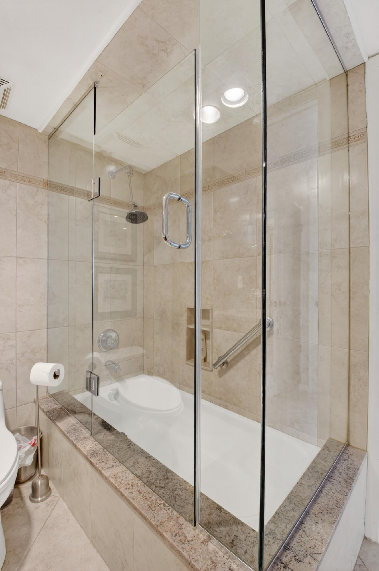 1180 South Ocean Boulevard, Unit 5C Boca Raton, FL 33432 - Photo 35 of 43 a bathroom with a granite countertop bathtub and a glass door shower