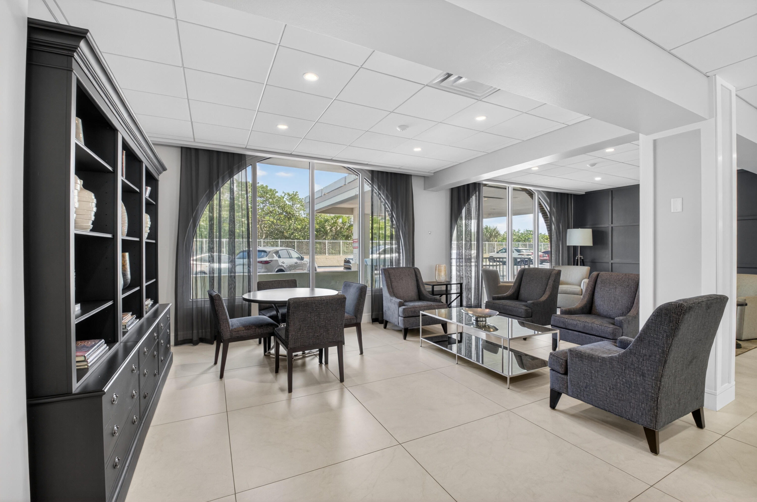1180 South Ocean Boulevard, Unit 5C Boca Raton, FL 33432 - Photo 7 of 43 a living room with furniture a floor to ceiling window and chairs