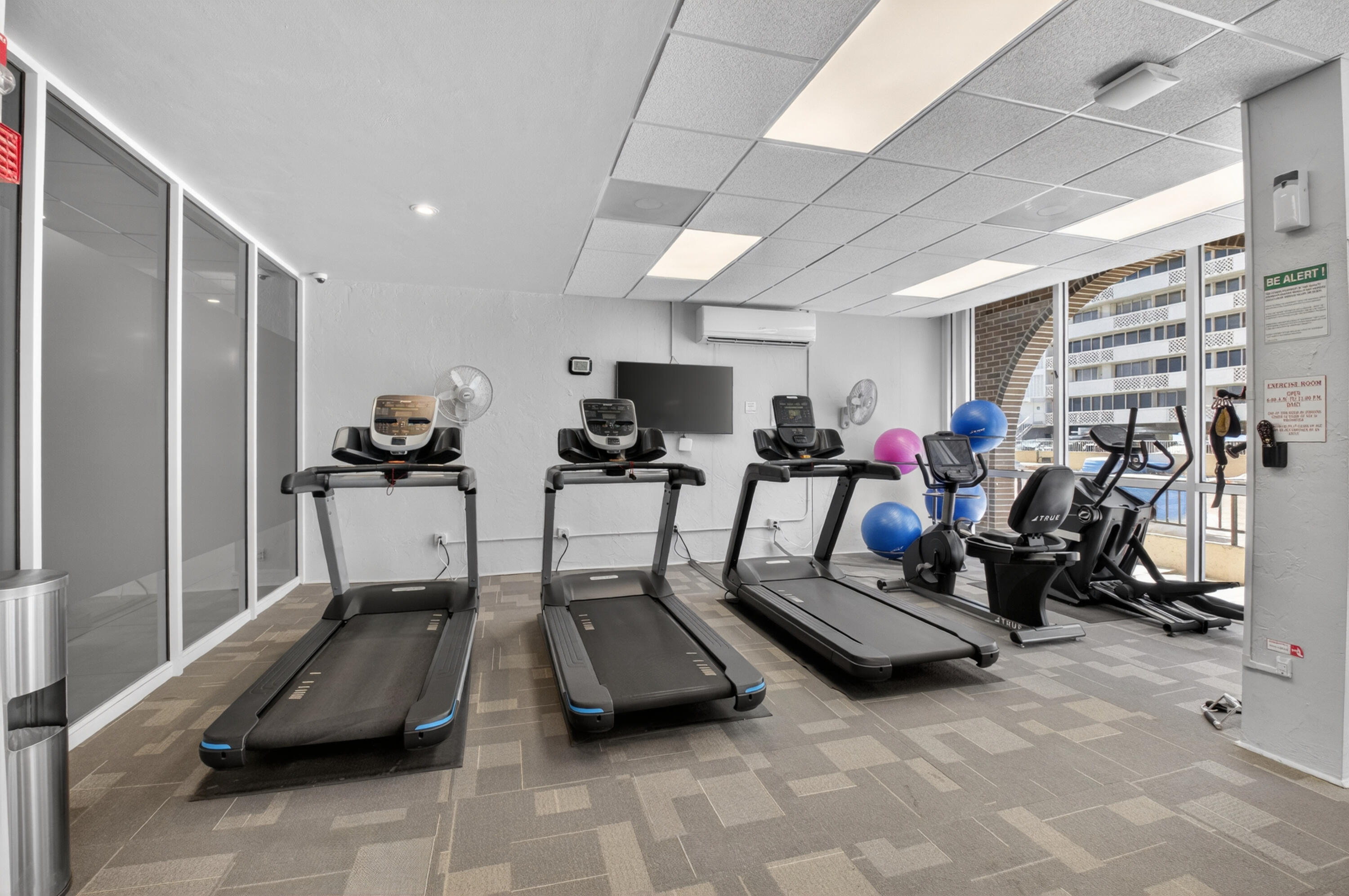 1180 South Ocean Boulevard, Unit 5C Boca Raton, FL 33432 - Photo 8 of 43 a room with gym equipment and a large window