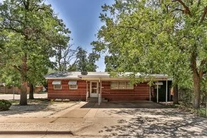 a view of a house with a yard and tree s