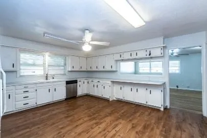 a large kitchen with granite countertop a stove cabinets and wooden floor