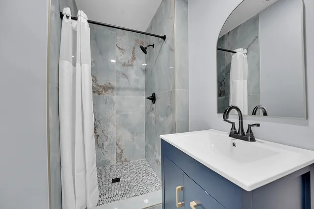 a bathroom with a sink a shower and a mirror