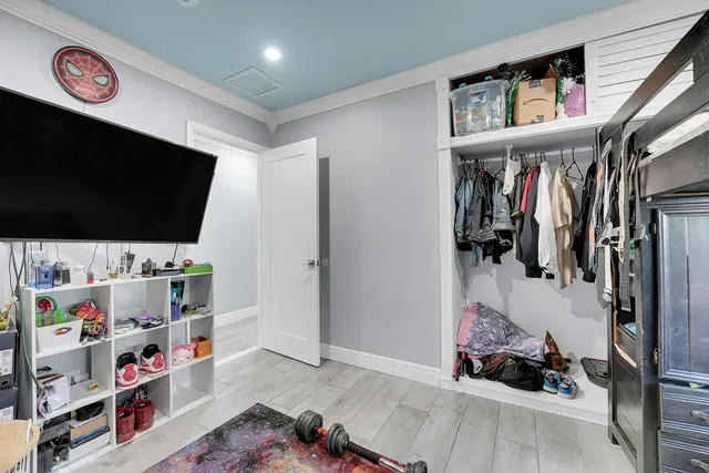 a view of walk in closet with clothes and shoes
