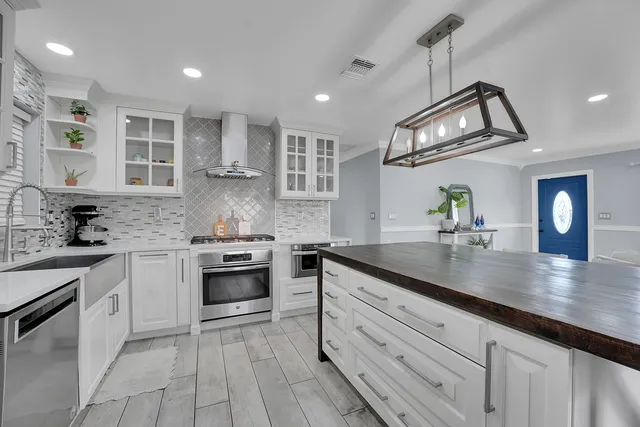 a kitchen with granite countertop a sink stainless steel appliances and cabinets