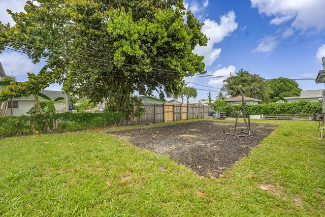 a view of a yard with plants and a bench