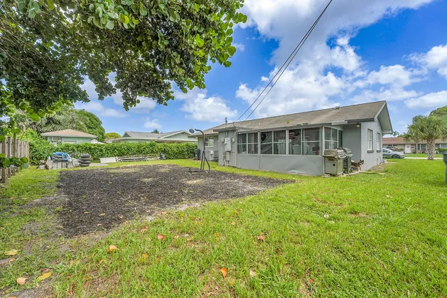 a view of house with backyard and a garden