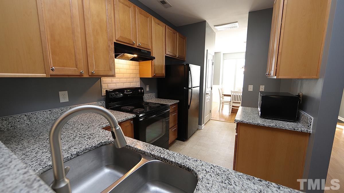 7626 Winners Edge Street Raleigh, NC 27617 - Photo 6 of 20 a kitchen with a stove and a refrigerator