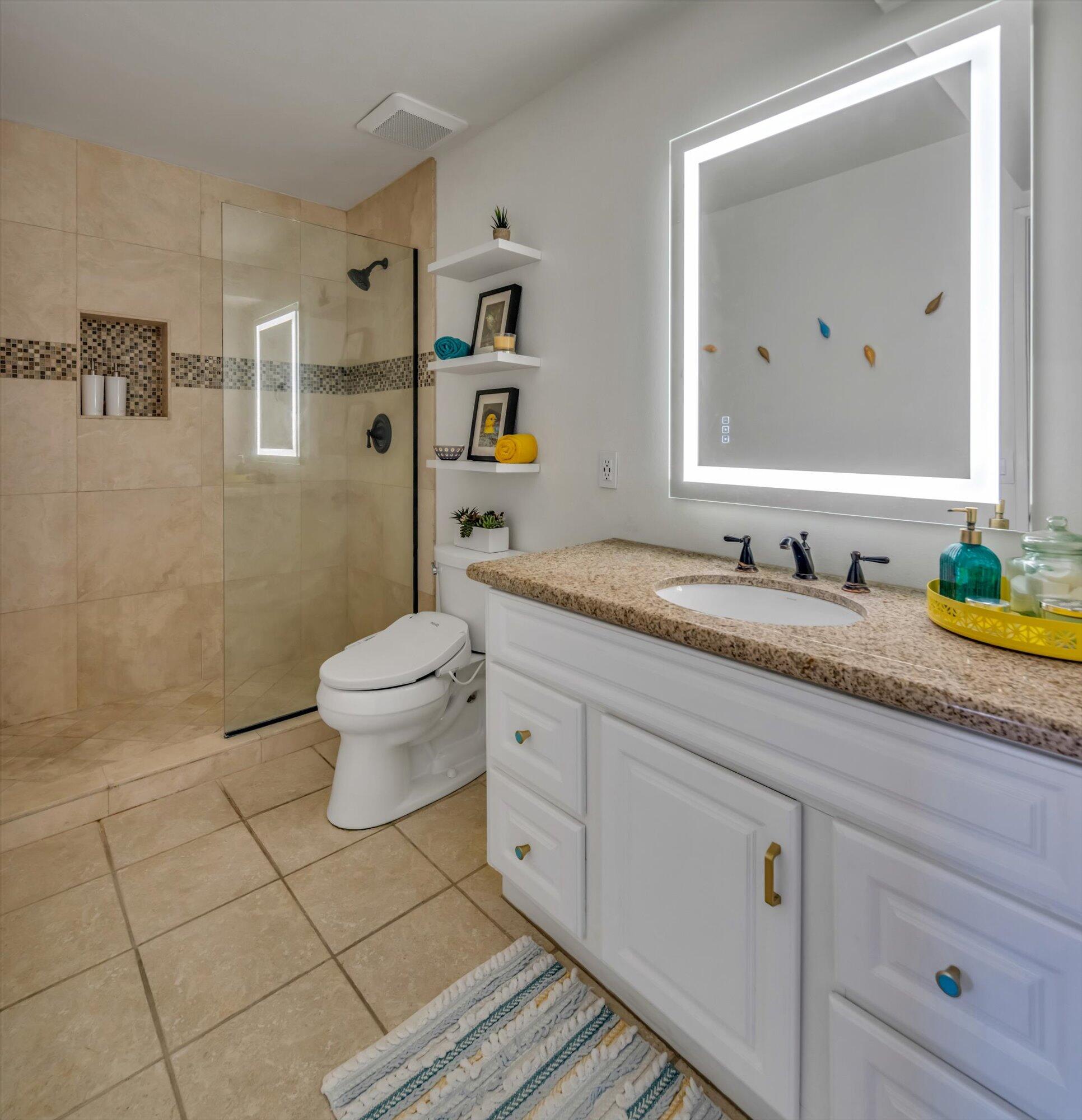1100 East Amado Road, Unit 12B1 Palm Springs, CA 92262 - Photo 20 of 29 a bathroom with a granite countertop toilet sink and mirror