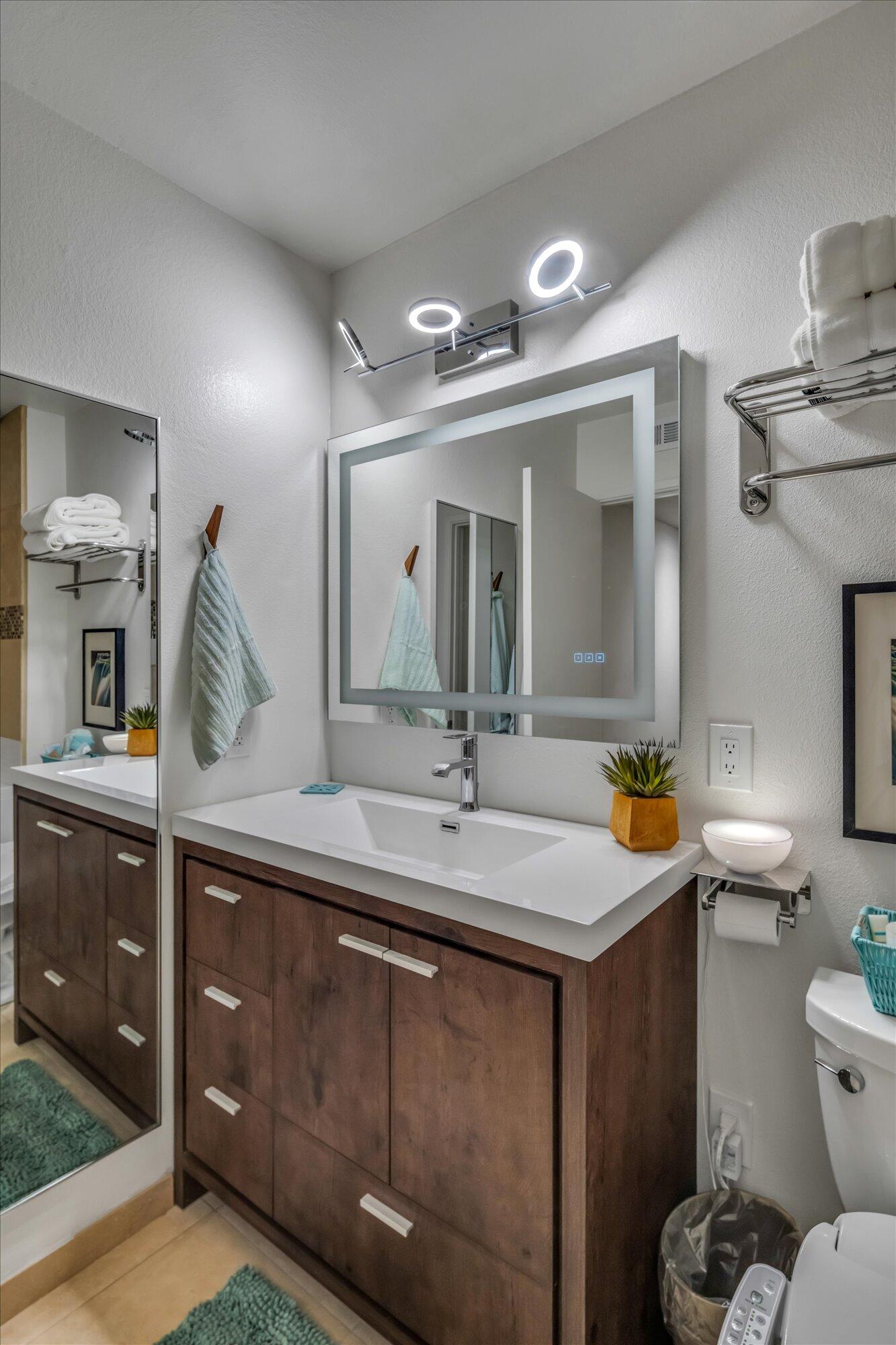 1100 East Amado Road, Unit 12B1 Palm Springs, CA 92262 - Photo 21 of 29 a bathroom with a granite countertop sink a toilet and a mirror