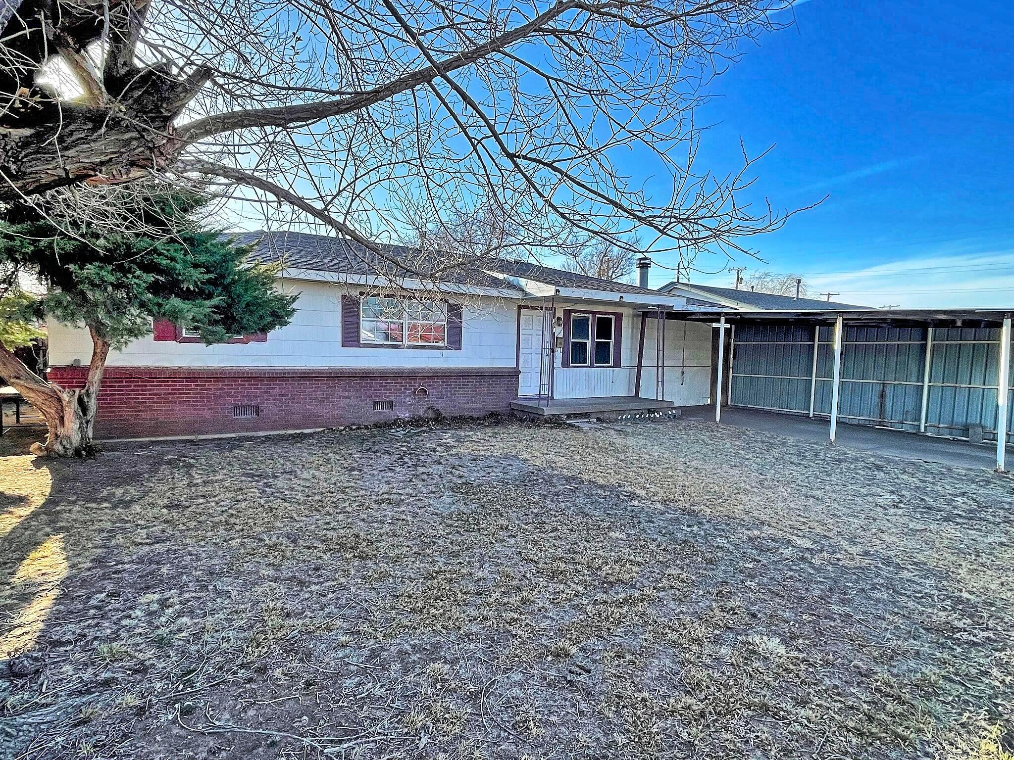 101 North Kentucky Street Perryton, TX 79070 - Photo 1 of 16 a front view of a house with garden
