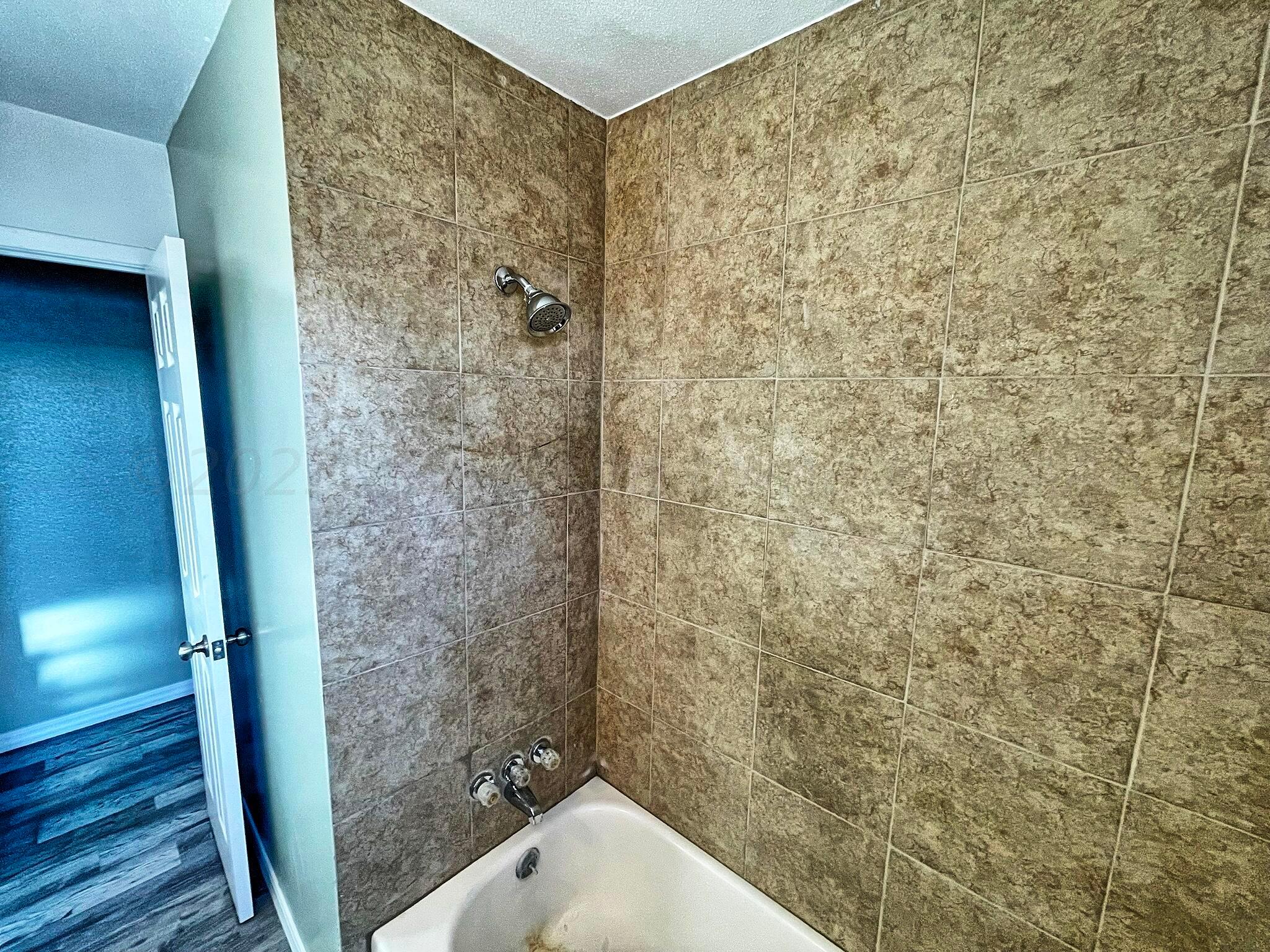 101 North Kentucky Street Perryton, TX 79070 - Photo 12 of 16 a bathroom with a shower and a sink