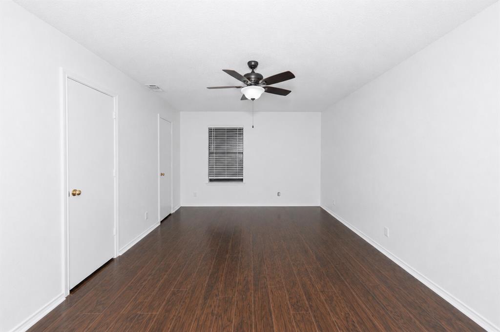 1001 Rosebud Drive Azle, TX 76020 - Photo 24 of 36 Spacious room featuring dark wood-finish flooring, a ceiling fan with integrated lighting, and a window with horizontal blinds