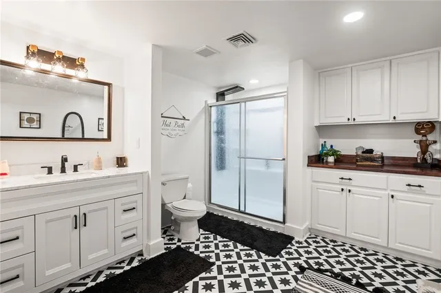 a kitchen with a refrigerator and white cabinets